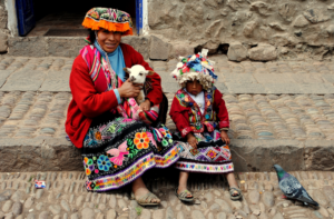 Indigenous Peruvian woman and boy, dressed in traditional colorful clothing