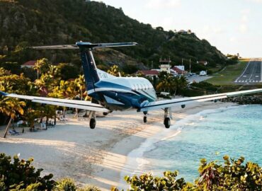 Private jet landing at St. Barths airport over the beach